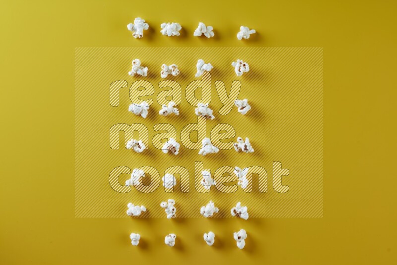 Popcorn flakes on a yellow background in different angles