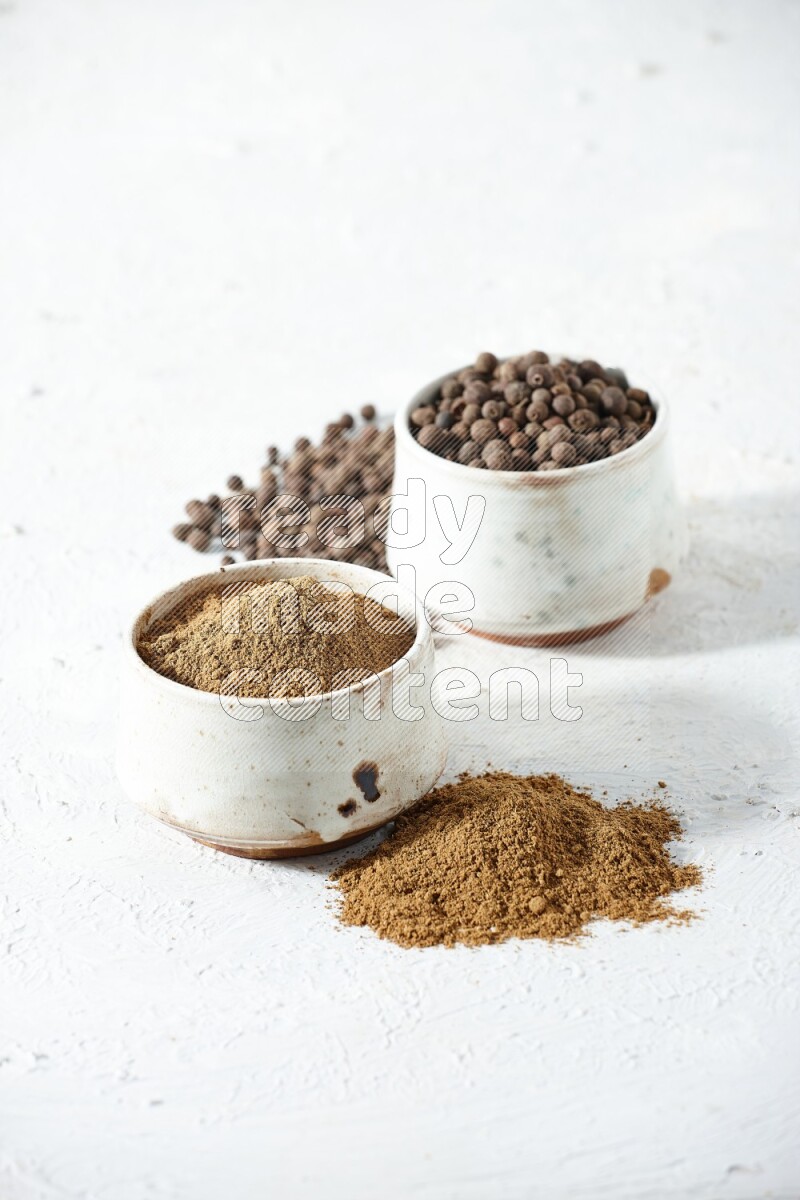 2 beige bowls, one full of powder and the other full of whole balls with balls and powder spreaded on a textured white flooring