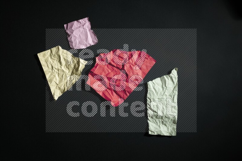 Crumpled multicolored paper on black background