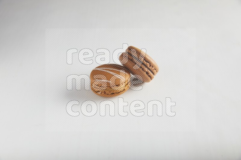45º Shot of of two assorted Brown Irish Cream, and Brown Coffee macarons  on white background