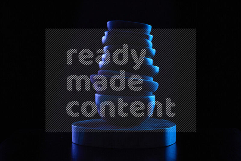 أدوات مطبخ خشبية مع حواف مضيئة ملونة على خلفية سوداء