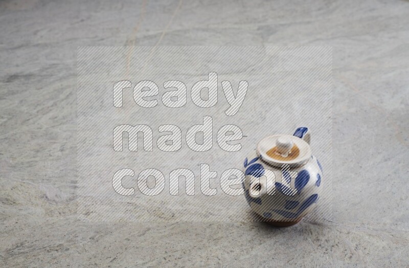 A pottery teapot on grey marble background