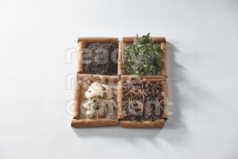 4 squares of cinnamon sticks full of tea, mint, star anise and ginger on white flooring