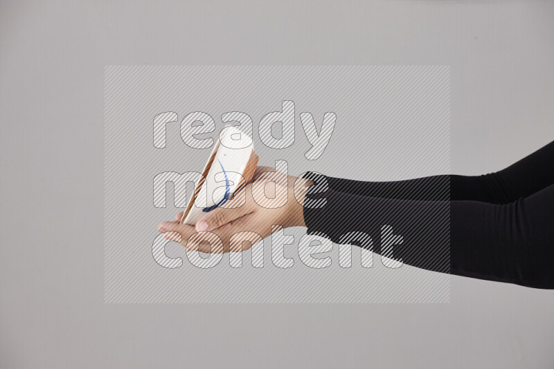 A woman in black abaya holding different pottery essentials in different positions