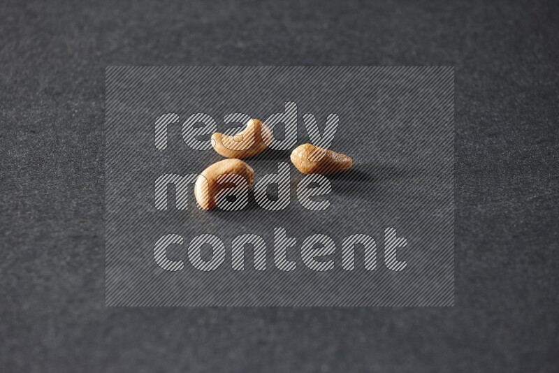 3 cashews on a black background in different angles
