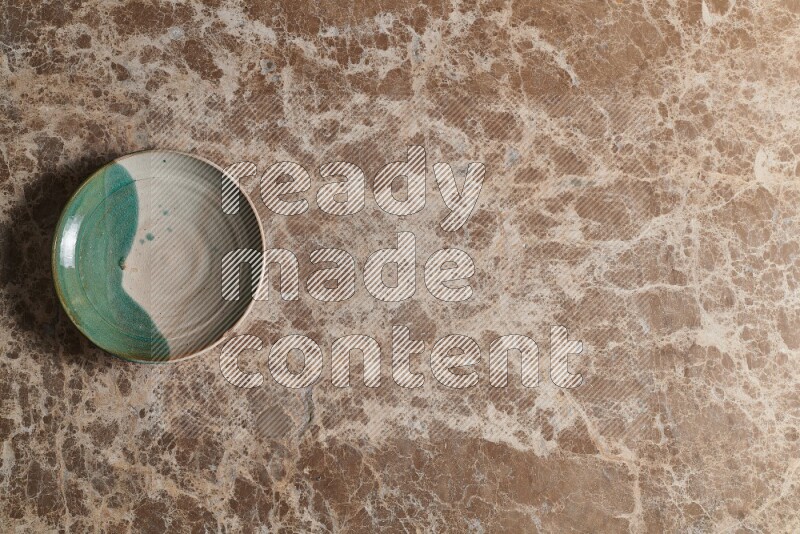 A decorative pottery plate on beige marble background