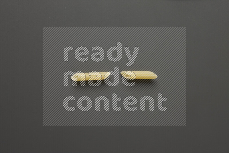 Mini penne pasta on grey background