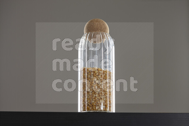 Pop corn in a glass jar on black background