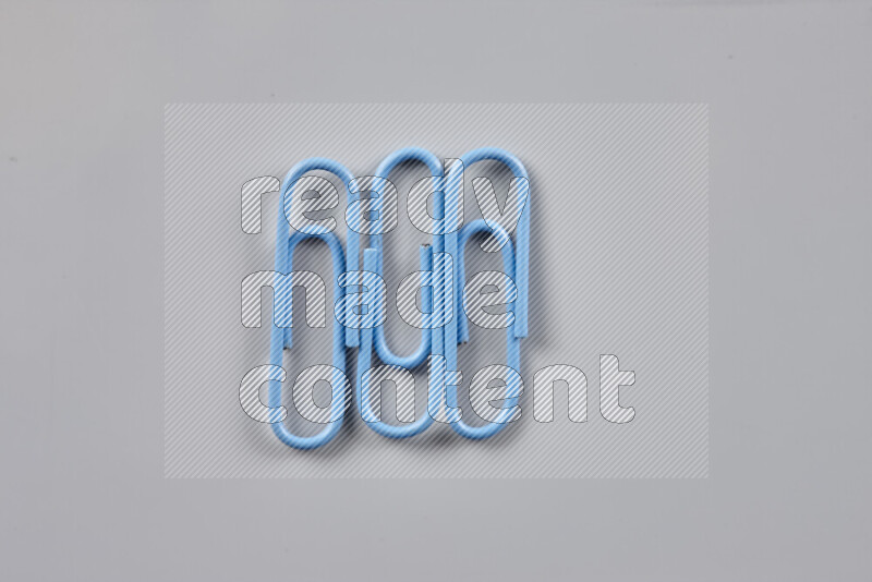 Blue paper clips isolated on a grey background