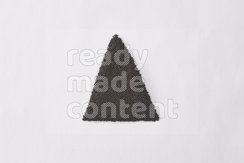 Black seeds in a triangle shape on a white flooring