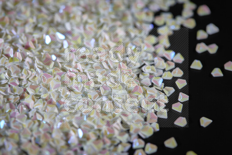 Colorful plastic shards for decoration scattered on a black background