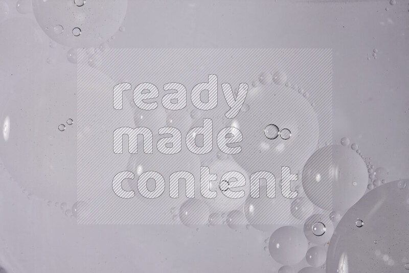 قطرات من الزيت على سطح الماء على خلفية بيضاء