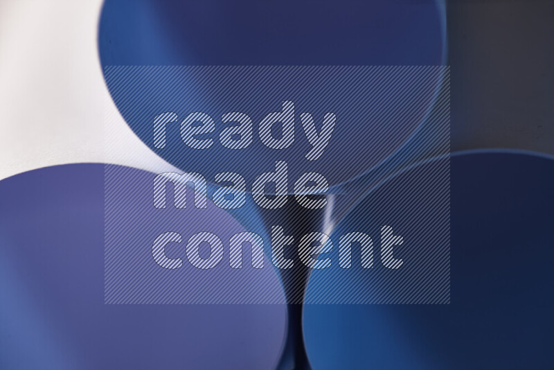 The image shows an abstract paper art with circular shapes in varying shades of blue