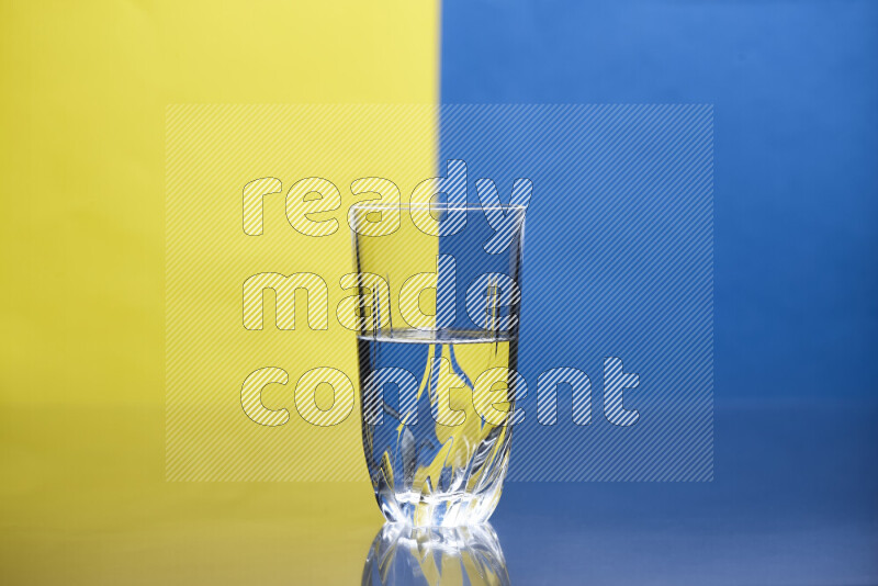 The image features a clear glassware filled with water, set against yellow and blue background