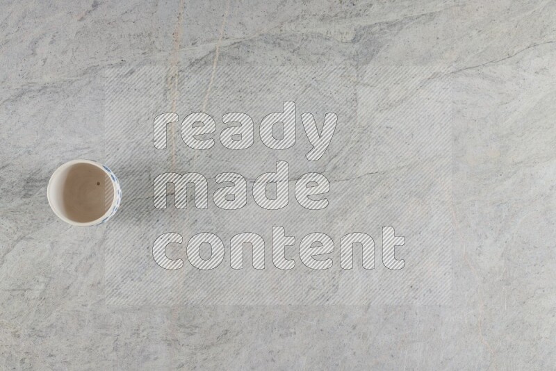 A multicolored pottery Cup on grey marble background