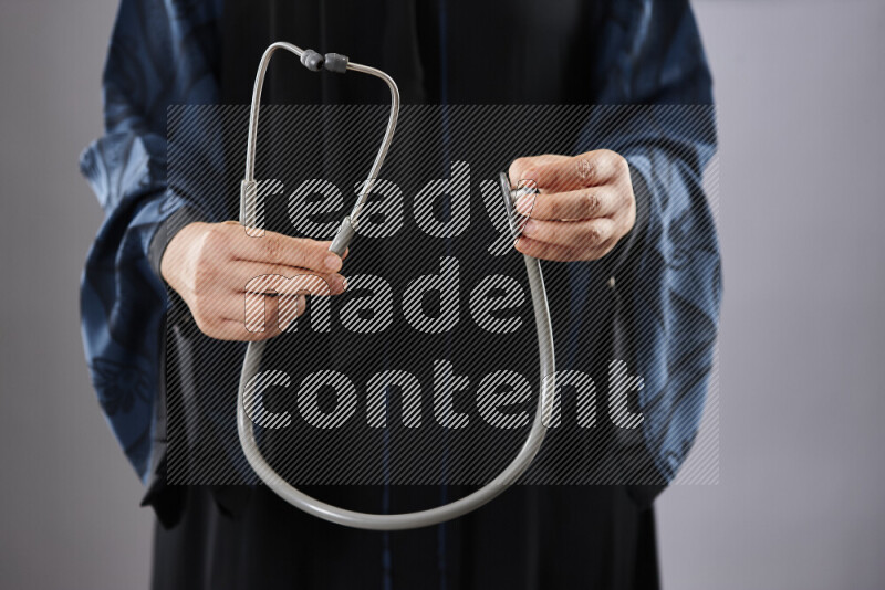 طبيبة ترتدي عباءة وملابس طبية في أوضاع متعددة