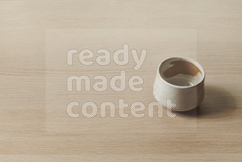 A multicolored pottery bowl on light wooden background
