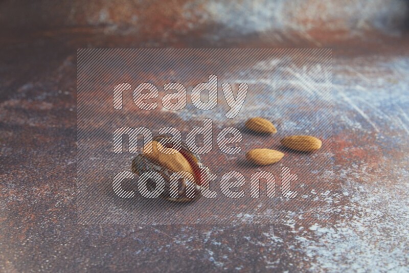 one almond stuffed madjoul date on a rustic reddish background