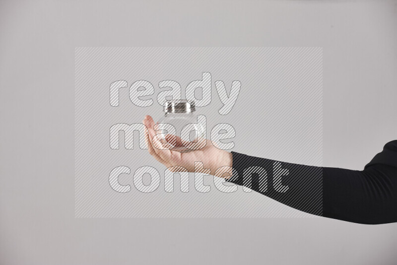 A woman in black abaya holding different glassware in different positions