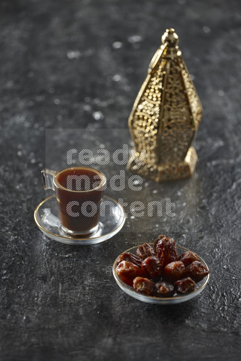 A golden lantern with different drinks, dates, nuts, prayer beads and quran on textured black background