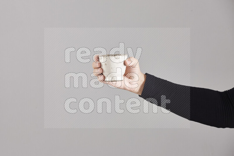 A woman in black abaya holding different pottery essentials in different positions