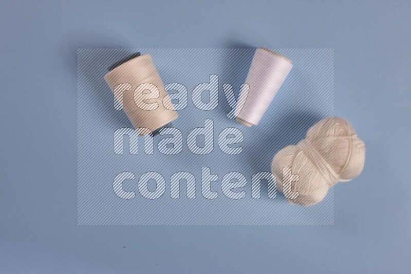 A white collection of sewing and tailoring tools arranged on a blue background