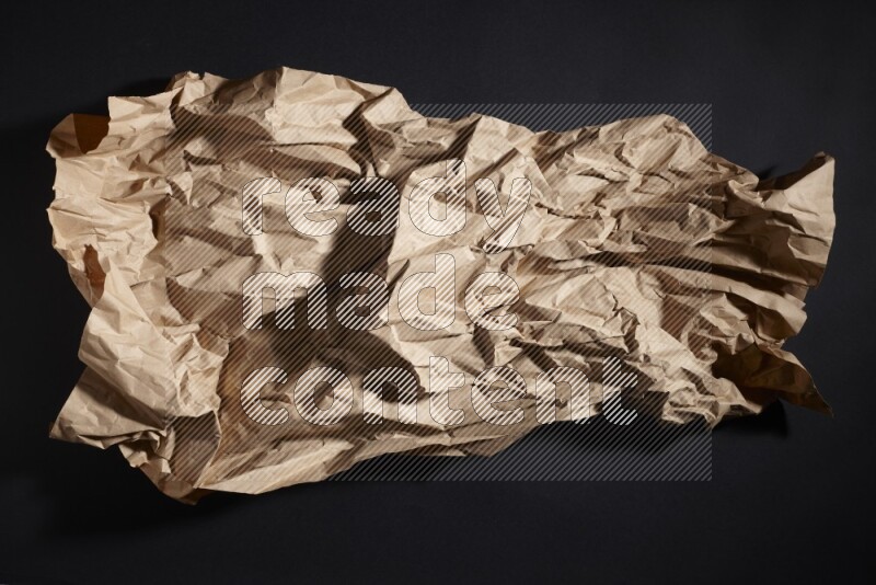 Crumpled craft paper on black background