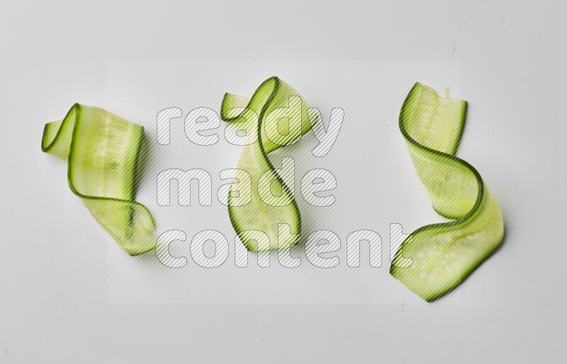 Three cucumber ribbons on a white background