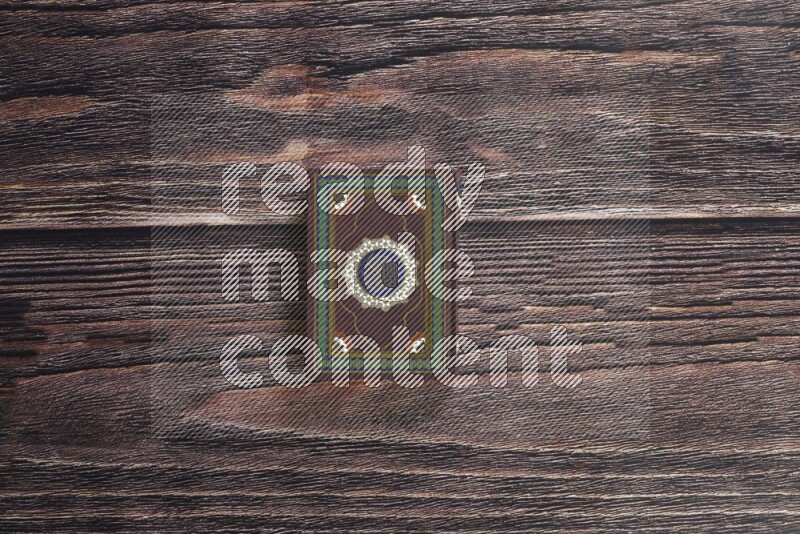 Quran with a prayer beads on wooden background