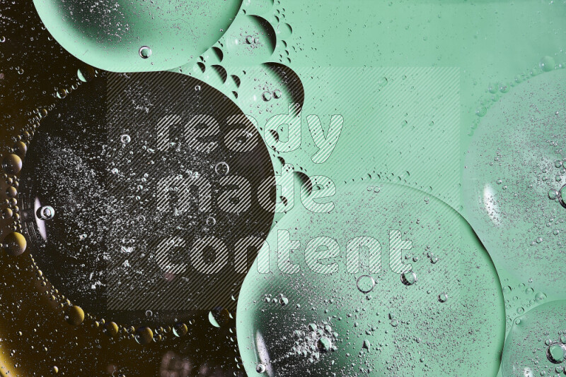 لقطات مقربة لفقاعات من الزيت على سطح الماء باللون الأسود والأخضر