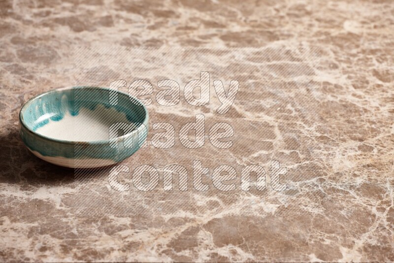 A multicolored pottery plate on beige marble background