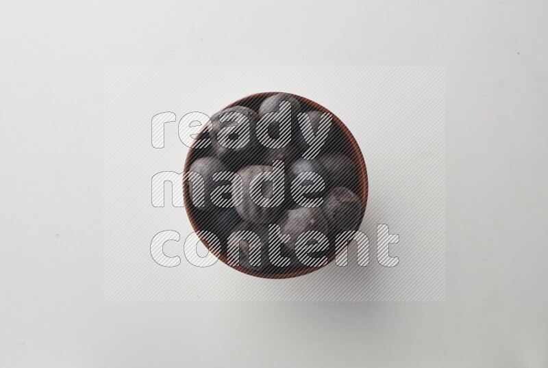 Top-view shot of dried lime (loomi) in a container on white background