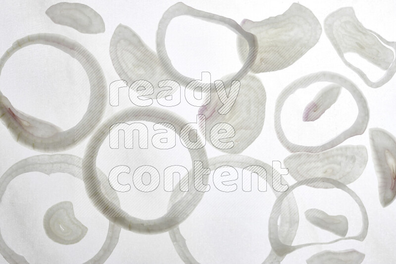 Onion slices on illuminated white background