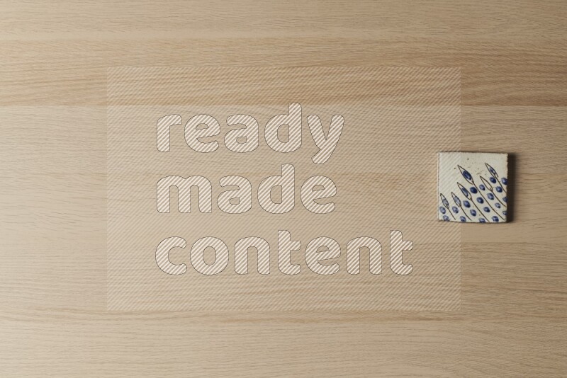 A decorative pottery coaster on light wooden background