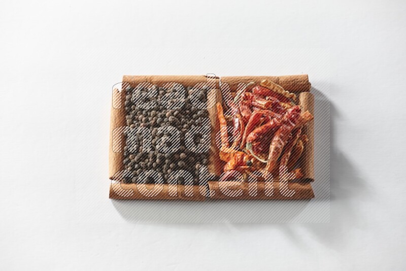 2 squares of cinnamon sticks full of red dried chilis and black pepper on white flooring