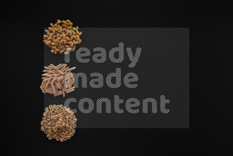 Different pasta types in 3 bunches on black background