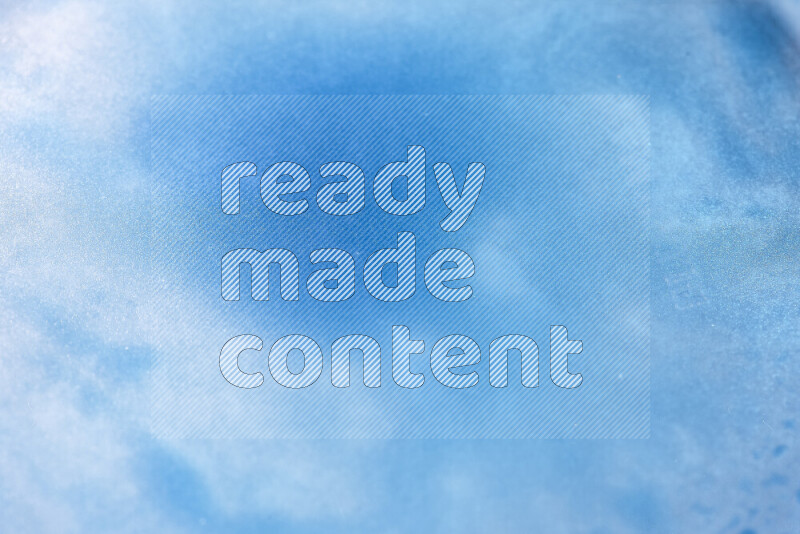 Close-ups of abstract blue watercolor drops on oil Surface on white background