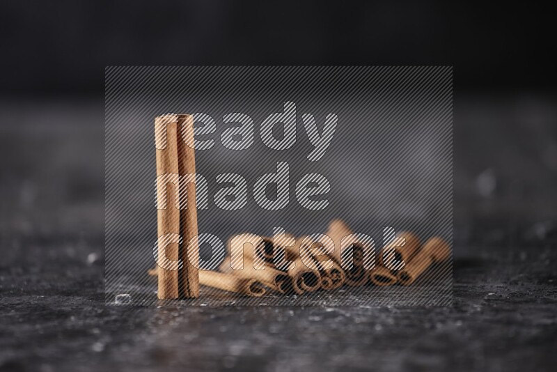 Cinnamon sticks on a textured black background