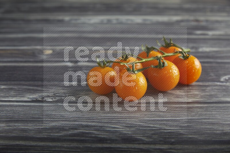 orange cherry tomato vein on a textured grey wooden background 45 degree