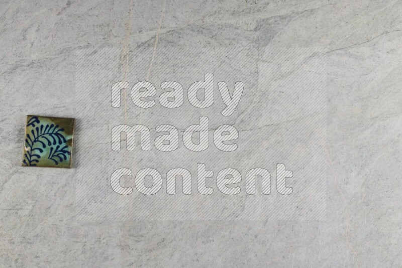 A decorative pottery coaster on grey marble background