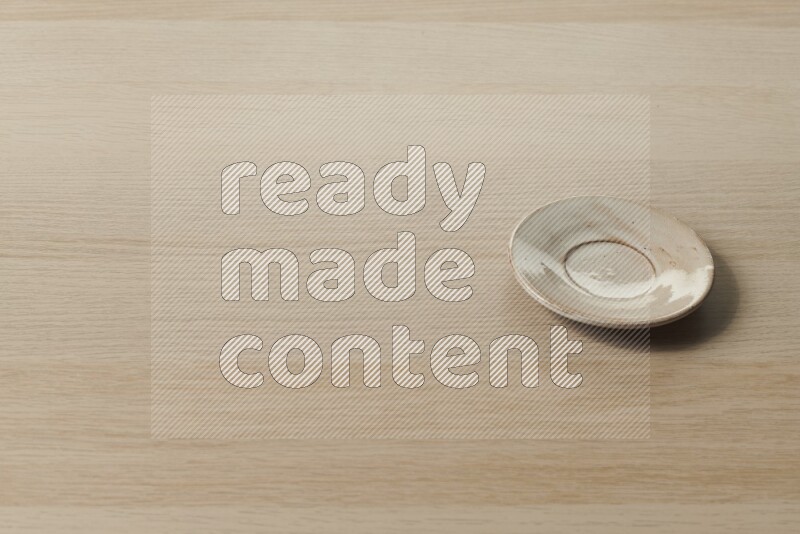A pottery coaster on light wooden background