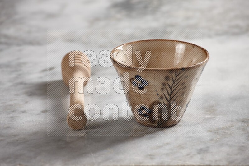 Decorative pottery bowl with wooden honey dipper on the side on grey marble background