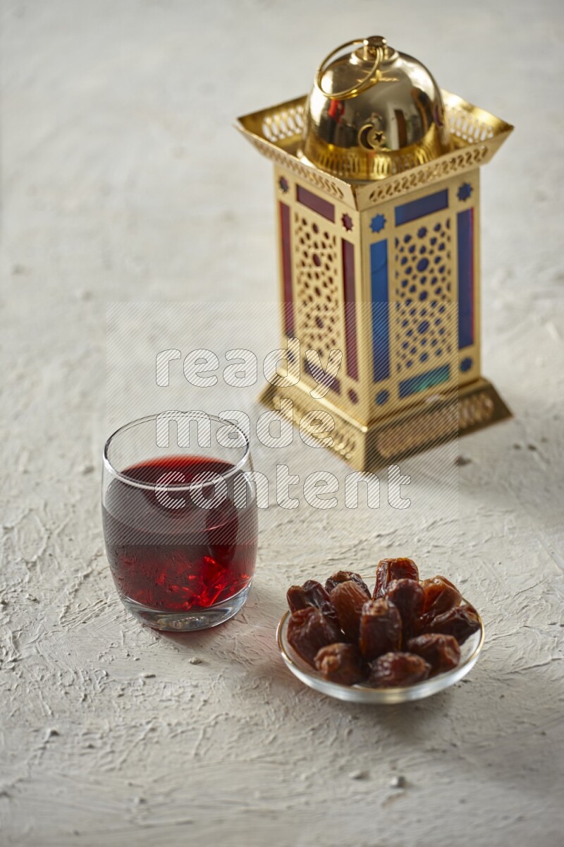 A golden lantern with different drinks, dates, nuts, prayer beads and quran on textured white background
