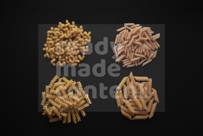 Different pasta types in bunches on black background
