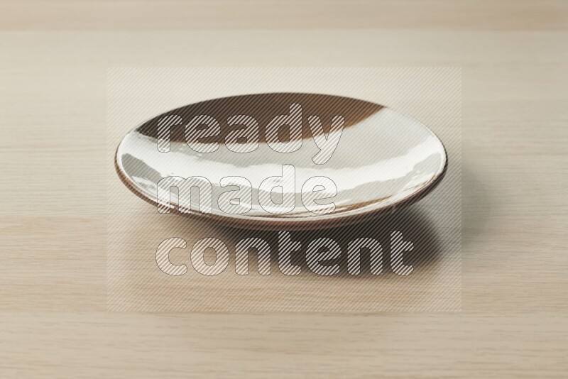 A multicolored pottery plate on light wooden background