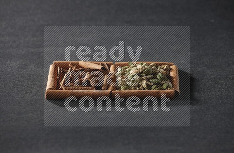 2 squares of cinnamon sticks full of cardamom and cinnamon on black flooring