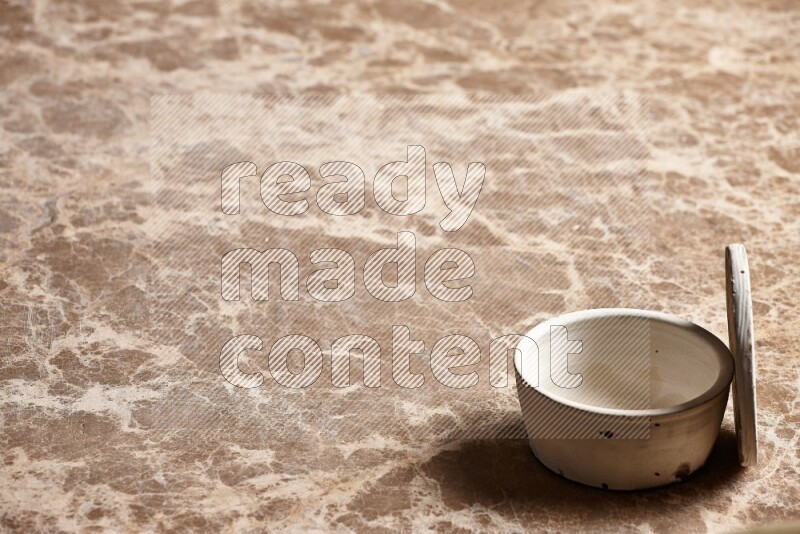 A white pottery bowl on beige marble background