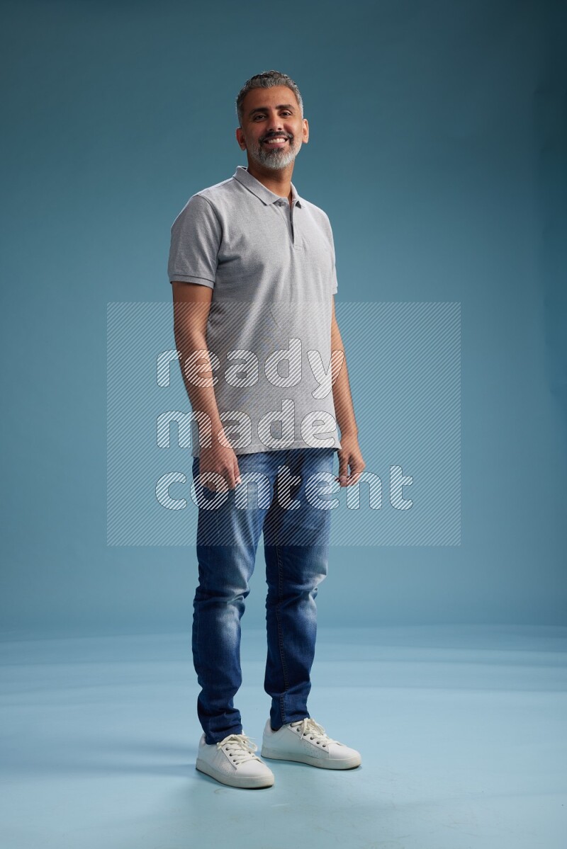 Man Standing Interacting with the camera on blue background