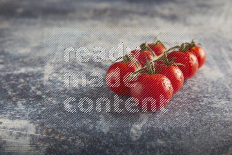 Red cherry tomato vein on a textured rusty blue background 45 degree
