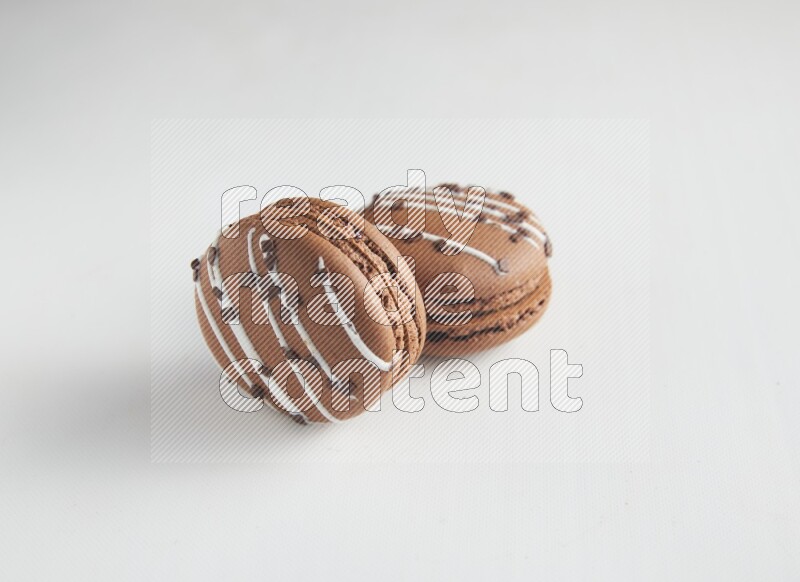 45º Shot of two Brown white Chocolate Caramel macarons on white background